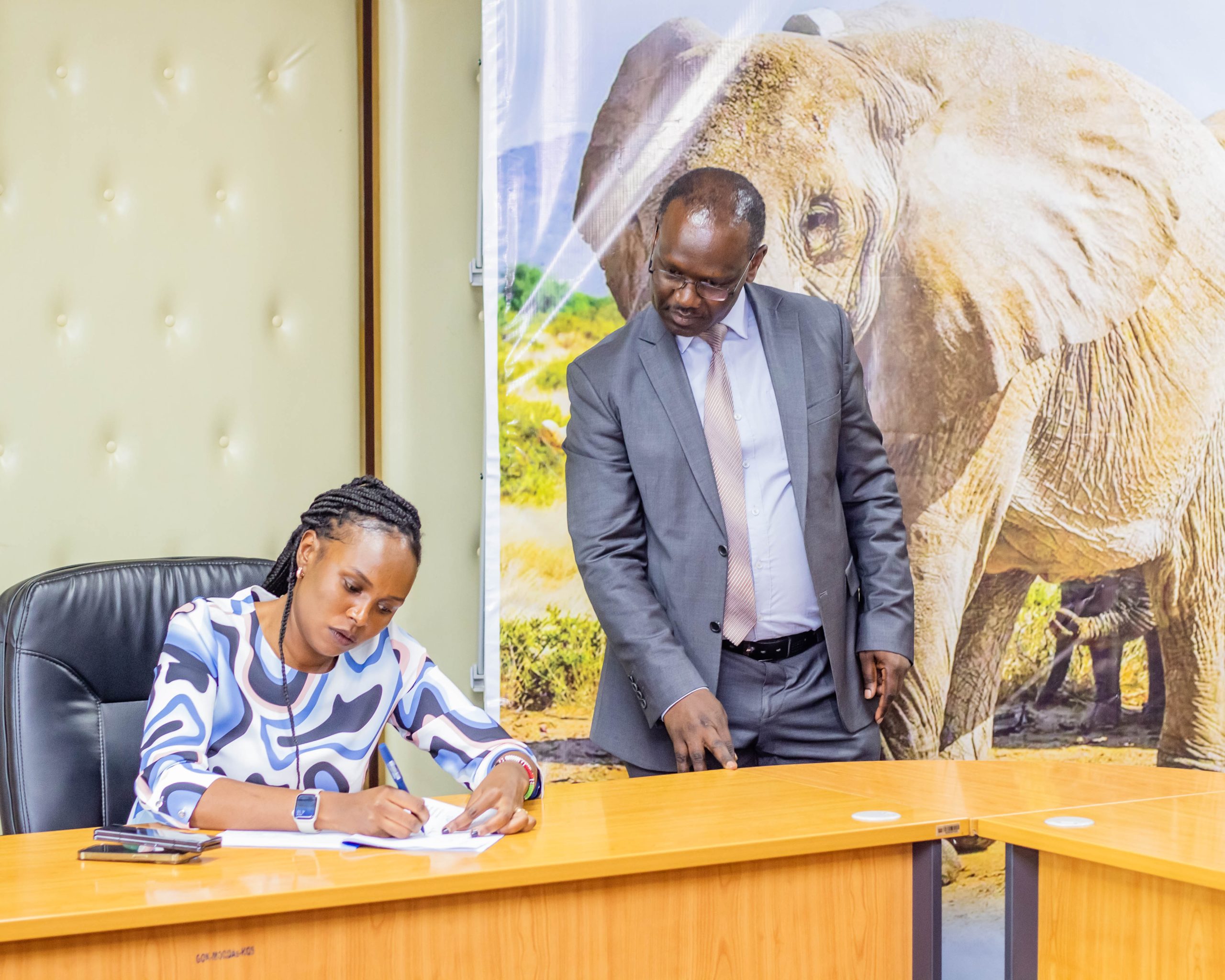 Principal Secretary Silvia Museiya counter signs the Performance Contract, witnessed by the Director of Planning, Mr Charles Ombuki