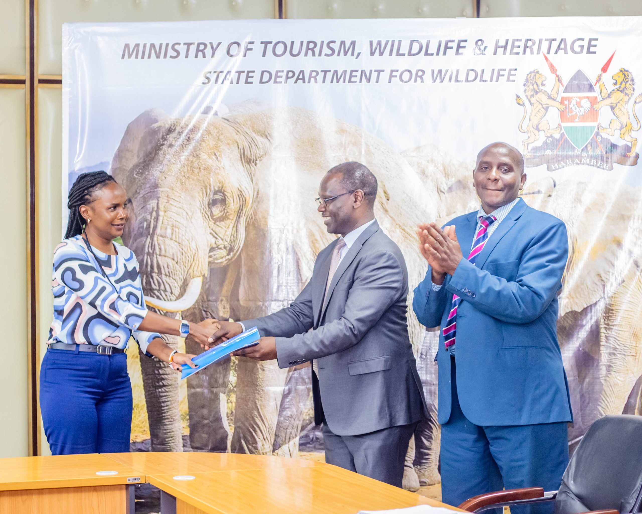 Principal Secretary for Wildlife Silvia Museiya hands over a signed copy of the Performance Contract Document to the Director of Planning, Mr Charles Ombuki.