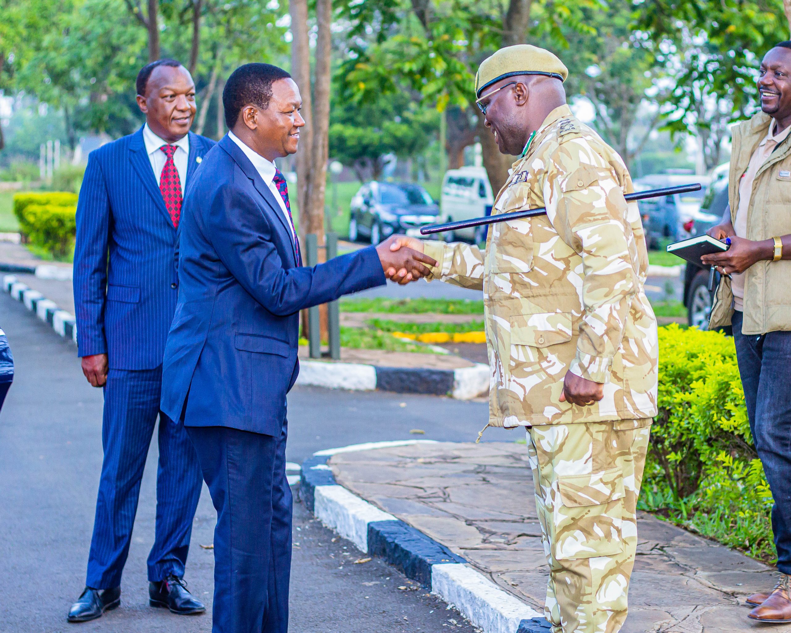 The Cabinet Secretary for Tourism and Wildlife, Dr. Alfred Mutua (in suit) being greeted by the Director General Kenya Wildlife Service, Dr. Erustus Kanga.