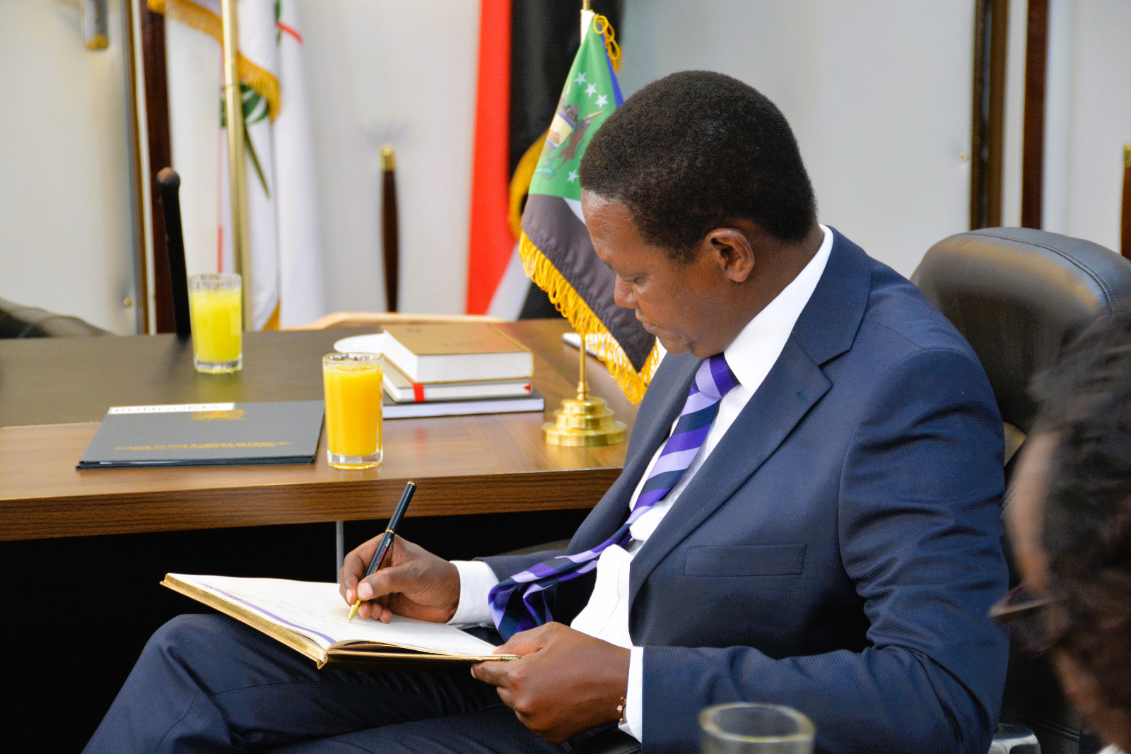 The Cabinet Secretary, Ministry of Tourism and Wildlife, Dr. Alfred Mutua, signing the Governor's visitors book.