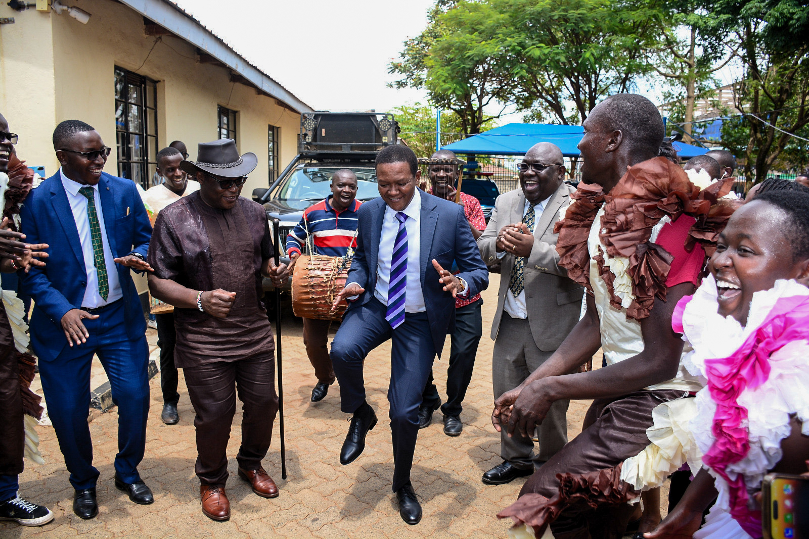 The Cabinet Secretary, Ministry of Tourism and Wildlife, Dr. Alfred Mutua (in navy blue suit & striped tie), the Governor of Bungoma County, H.E. Rt. Hon. Kenneth Lusaka (wearing a hat), and other officials, participating in the "Kamabeka" dance.