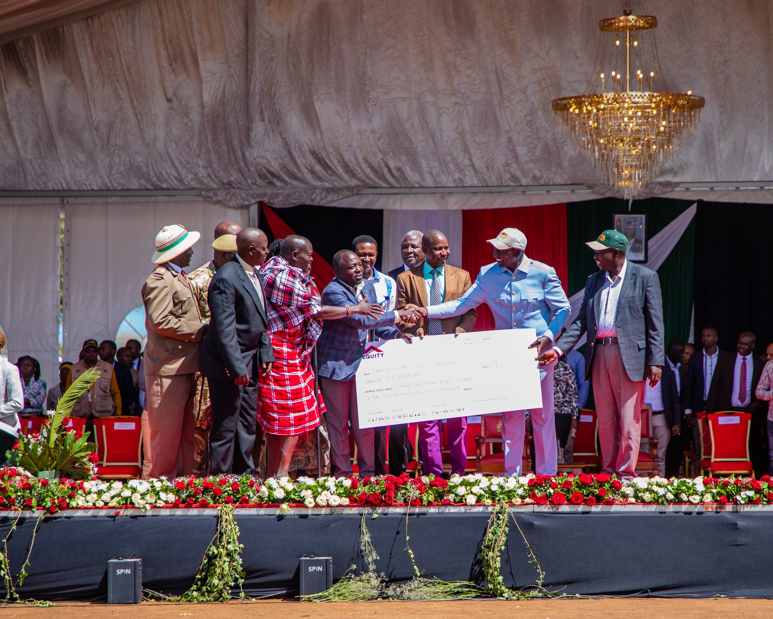President William Ruto holds a dummy cheque to symbolise the launch of payment of Sh 960 million as compensation to families and victims who suffered death, injuries, damages to crops and property and livestock predation across the country. The event was held in Rumuruti Laikipia County.